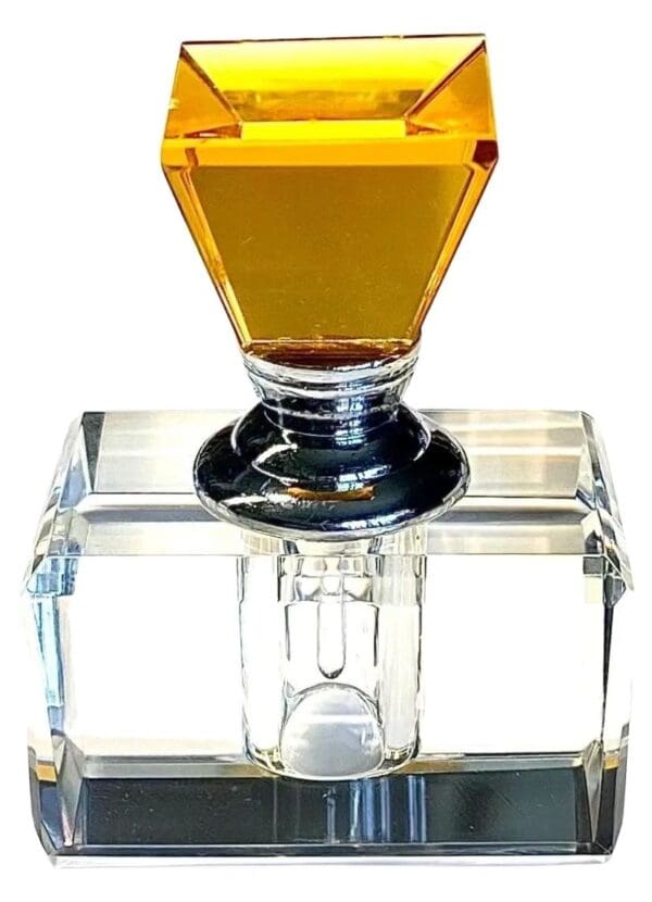 A square glass container with a yellow top.