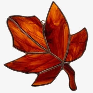 A stained glass leaf hanging on the wall.